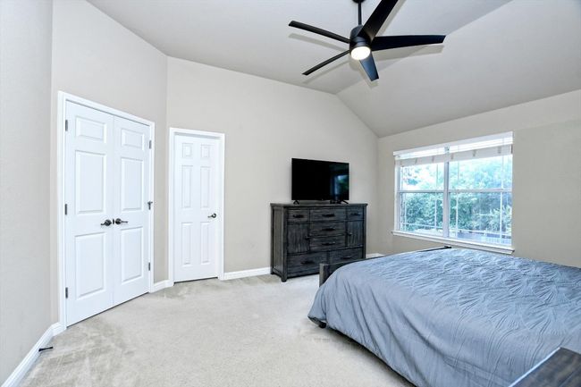 Bedroom with lofted ceiling, carpet flooring, baseboards, and a ceiling fan | Image 16