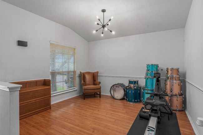 Exercise room featuring a chandelier, wood finished floors, and lofted ceiling | Image 7