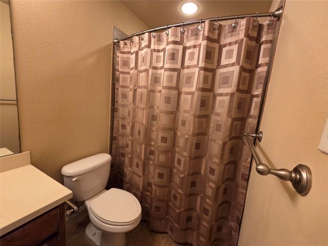 Full bathroom featuring a textured wall, vanity, and a shower with shower curtain | Image 27