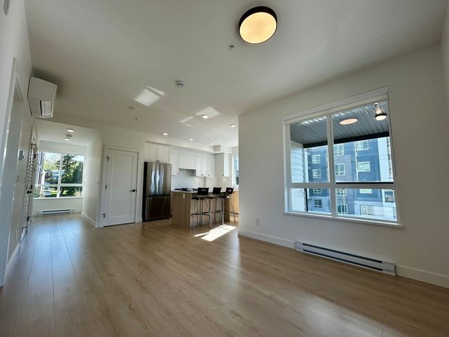 Unfurnished living room with baseboard heating, baseboards, light wood finished floors, and recessed lighting | Image 6