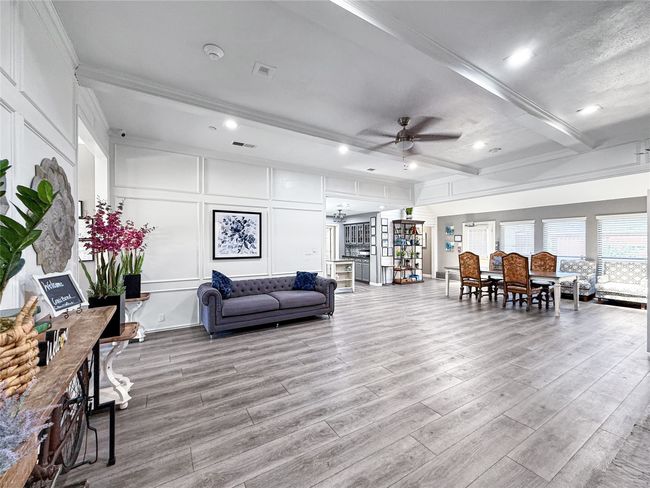 Living room featuring a decorative wall, beam ceiling, ceiling fan, wood finished floors, and recessed lighting | Image 8