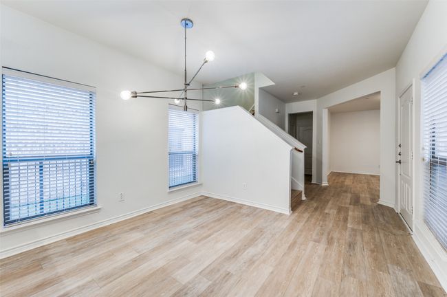 Step into a spacious, open-concept living and dining area where light-toned flooring enhances the sense of space and warmth. Expansive windows invite natural light to pour in, creating a bright and welcoming atmosphere perfect for everyday living and entertaining. | Image 4