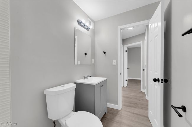 Half bathroom featuring toilet, vanity, wood finished floors, and baseboards | Image 18