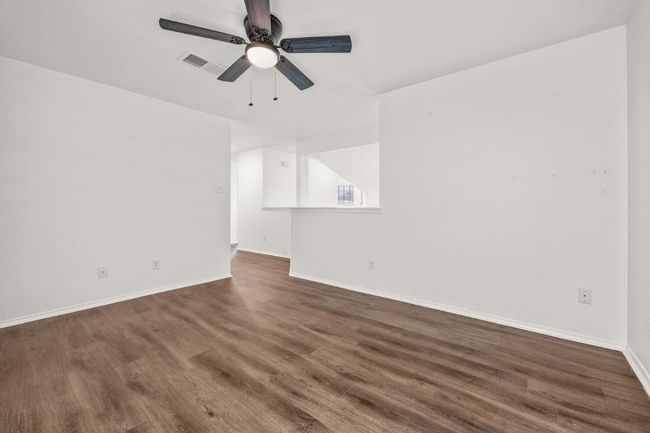 Unfurnished room with a ceiling fan, wood finished floors, baseboards, and visible vents | Image 18