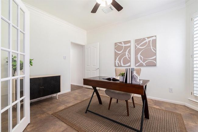 Working from home in this study tucked away behind French doors won't seem so cut off in this split floor plan home with primary wing! That door actually gives you access to the powder room, leading down the hall to the family room or primary suite! | Image 8
