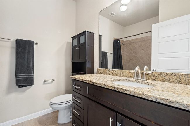 The shared full bath upstairs features granite finishes and a shower/tub combo. | Image 17