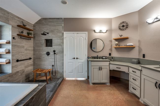 Another view of primary bath showing walk in closet doors and vanities with quartz counters | Image 27