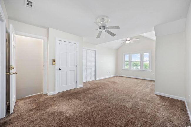 Unfurnished bedroom with carpet, baseboards, a ceiling fan, and lofted ceiling | Image 24