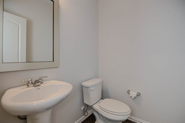 Half bath with baseboards, toilet, and a sink | Image 21
