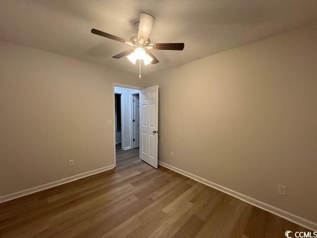 Spare room featuring baseboards, ceiling fan, and dark wood-style floors | Image 17