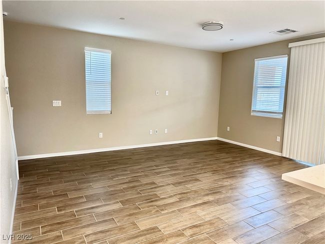Spare room with baseboards, visible vents, and wood finished floors | Image 16