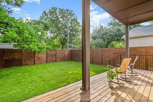 Wooden deck with a fenced backyard and a yard | Image 13
