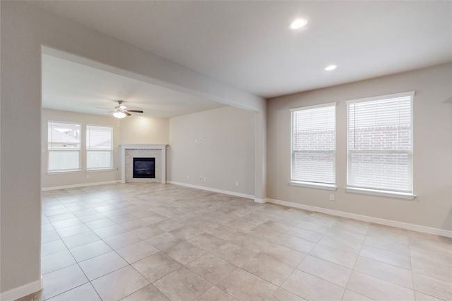 Unfurnished living room with light tile patterned floors, a ceiling fan, baseboards, and recessed lighting | Image 11
