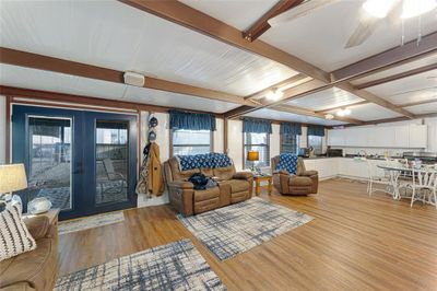 Living room featuring beam ceiling, french doors, light hardwood / wood-style flooring, and a wealth of natural light | Image 2