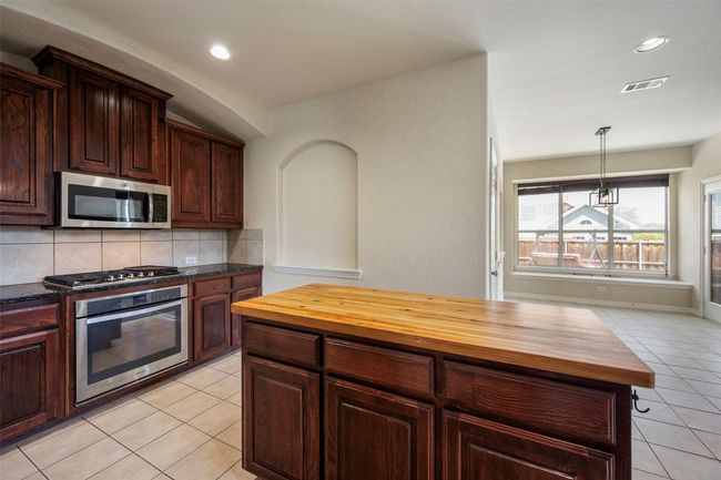 Gas cooktop and stove, and a custom handmade oak countertop on the kitchen island! | Image 22