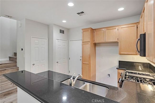 KITCHEN WITH STAINLESS APPLIANCES, BREAKFAST BAR AND PANTRY | Image 16