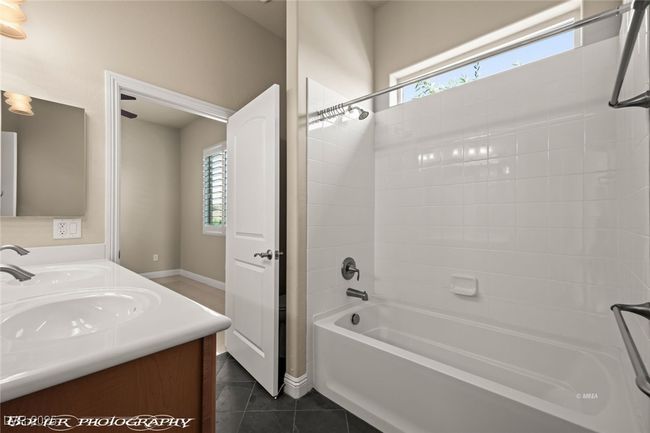 Full bath featuring a sink, double vanity, plenty of natural light, and shower / bath combination | Image 37