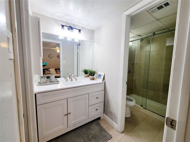 Bathroom featuring tile patterned flooring, vanity, toilet, and walk in shower | Image 14