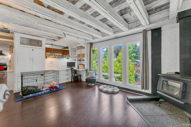Miscellaneous room featuring beamed ceiling, wood finished floors, a wood stove, and wooden ceiling | Image 16