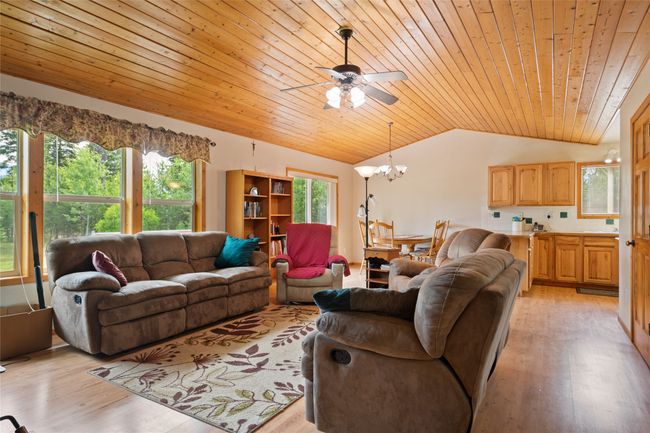 Living area with vaulted ceiling, wood ceiling, light wood finished floors, a chandelier, and ceiling fan | Image 19