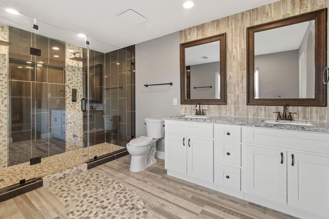 The primary bathroom features double sinks with framed mirrors and decorative tile backsplash. | Image 19