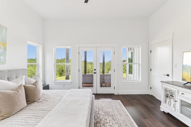 Bedroom with access to outside, dark wood-type flooring, a high ceiling, and a ceiling fan | Image 19