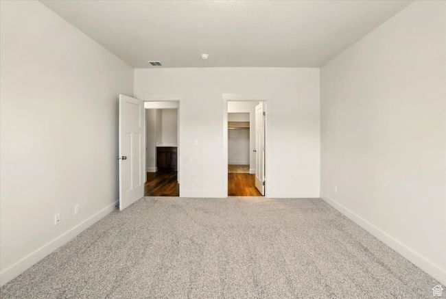 Unfurnished bedroom featuring carpet floors, baseboards, a spacious closet, and a closet | Image 16