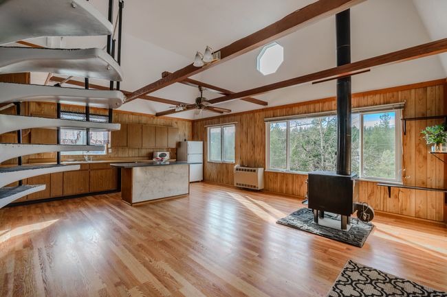 Kitchen with light hardwood / wood-style floors, wood walls, white refrigerator, and heating unit | Image 12