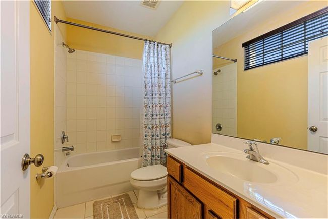 Full bath with vanity, tile patterned flooring, visible vents, toilet, and shower / bath combo | Image 15
