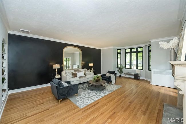 Living room features tall ceilings with newly finished original wood floors, plenty of natural light, and crown molding | Image 4