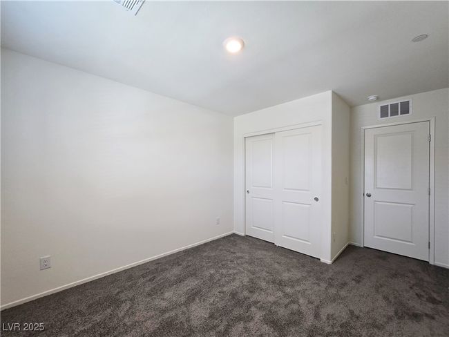 Unfurnished bedroom with dark carpet, baseboards, and a closet | Image 21