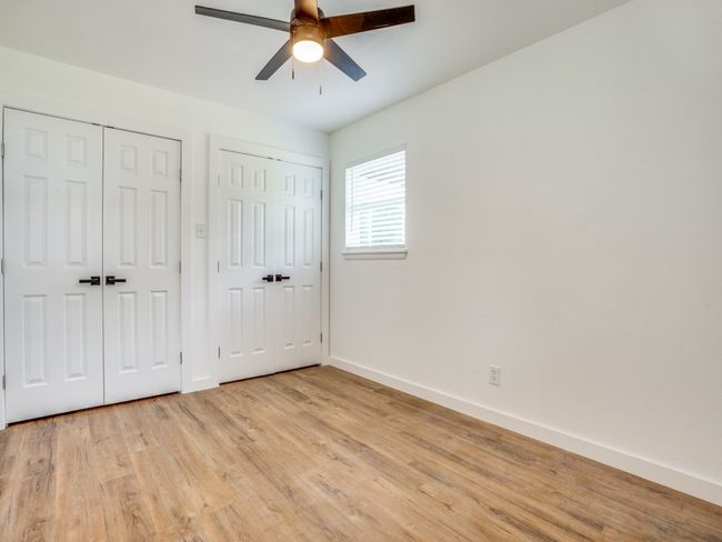 Unfurnished bedroom featuring multiple closets, baseboards, light wood-style flooring, and a ceiling fan | Image 11