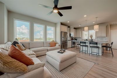 Experience the spacious living room on the second floor of this three-story home. Featuring ample lighting, sleek flooring with no carpet, and a stylish TV wall unit with an electronic fireplace, this inviting space is perfect for relaxation and entertainment. | Image 3