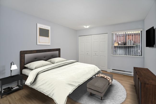 Bedroom with a baseboard radiator, wood finished floors, and a closet | Image 10