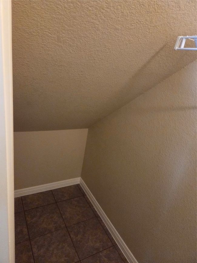 Additional living space featuring dark tile patterned flooring, lofted ceiling, and a textured ceiling | Image 9