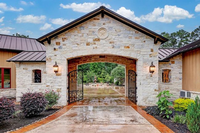 The driveway entrance boasts a custom designed dual iron front gate. | Image 46