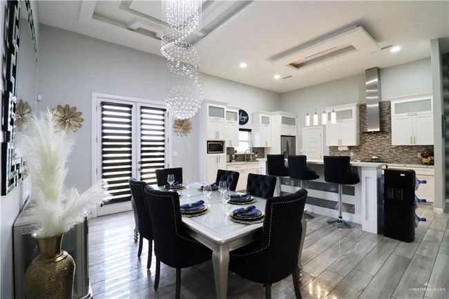 Dining area featuring a chandelier, light wood finished floors, and recessed lighting | Image 4