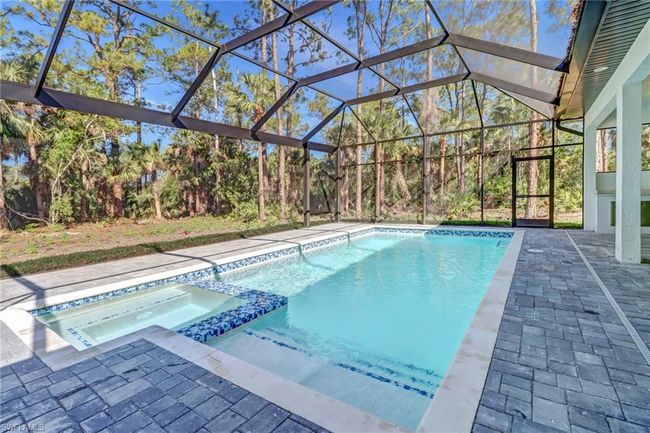 View of pool featuring an in ground hot tub, a patio, and glass enclosure | Image 44