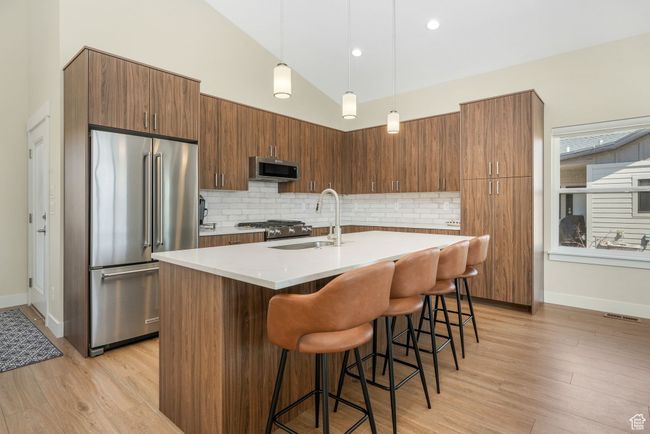 The spacious kitchen, featuring a gas range, generous countertop space, and sleek stainless steel appliances, including a double-door refrigerator and pull-out freezer, offers both functionality and style, perfect for cooking and entertaining. | Image 24