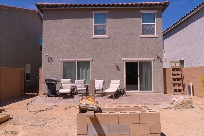 Rear view of house featuring stucco siding, a tile roof, fence, and a patio | Image 64