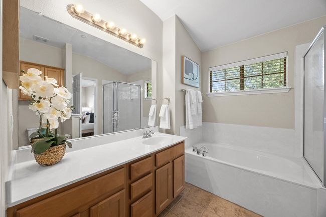Ensuite bathroom featuring vanity, a separate shower, a garden tub, and tile flooring | Image 25