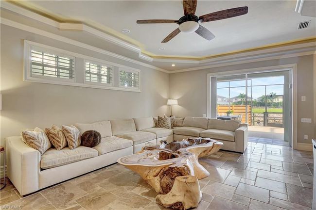 Living room with visible vents, a healthy amount of sunlight, crown molding, and a tray ceiling | Image 24