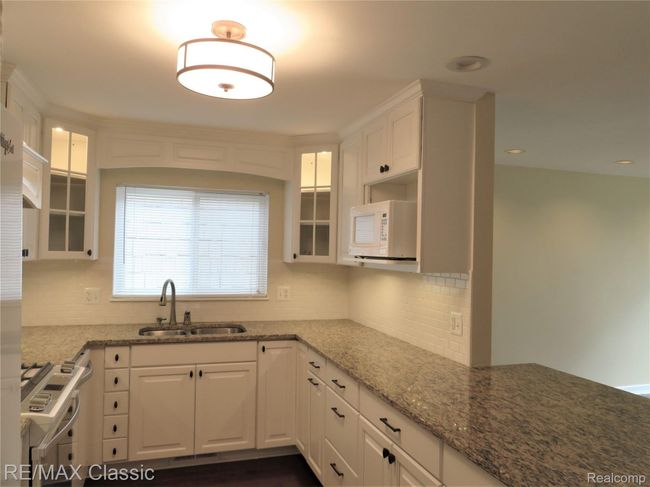 High end kitchen with quality amenities, like raised panel cabinets with glass inserts, granite tops and oil rubbed bronze accents. | Image 5