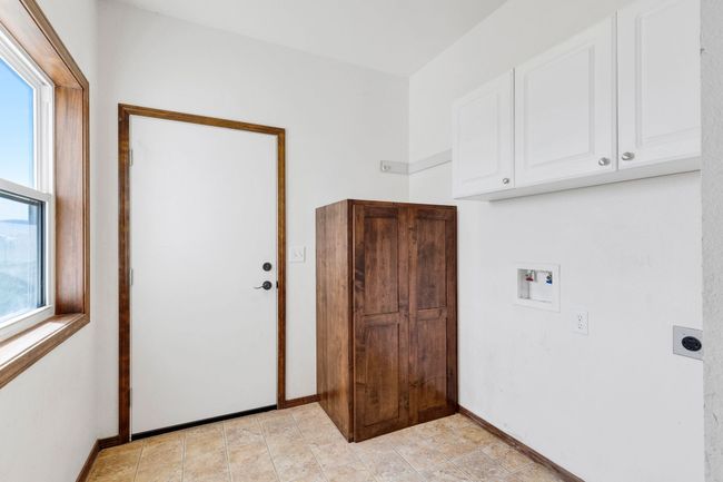 Laundry room with cabinet space, hookup for a washing machine, electric dryer hookup, and baseboards | Image 45