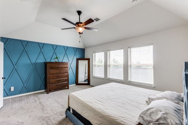 Carpeted bedroom featuring lofted ceiling and ceiling fan with bluetooth controlled light | Image 14