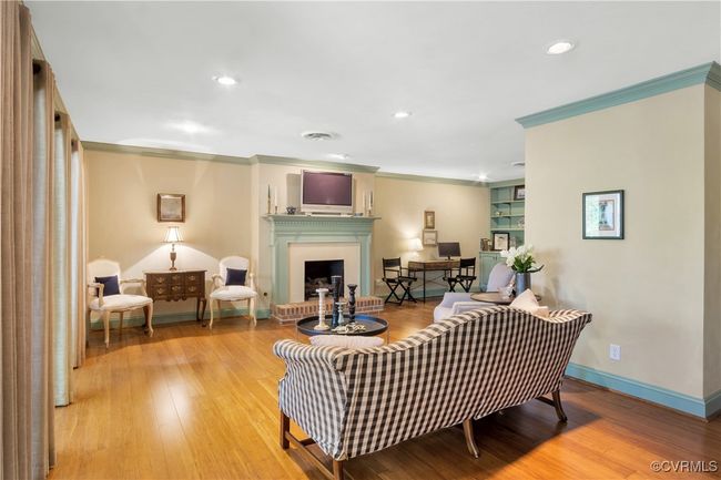Living area featuring crown molding, wood finished floors, a fireplace, and baseboards | Image 10