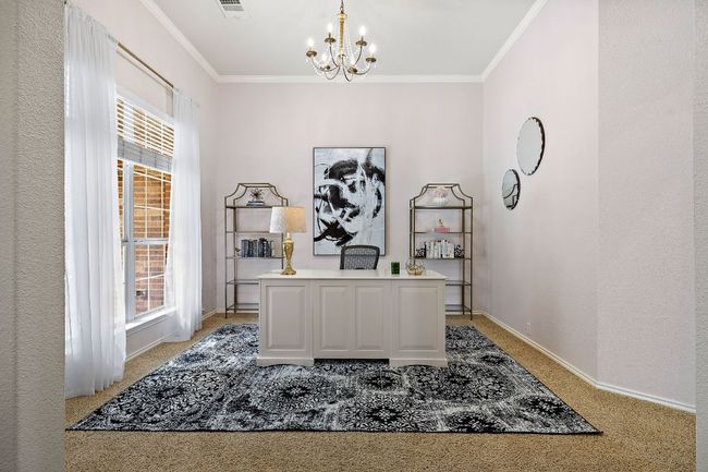 Living area featuring carpet floors, ceiling fan, healthy amount of natural light, and baseboards area with light carpet, a chandelier, plenty of natural light, baseboards, and crown molding | Image 5