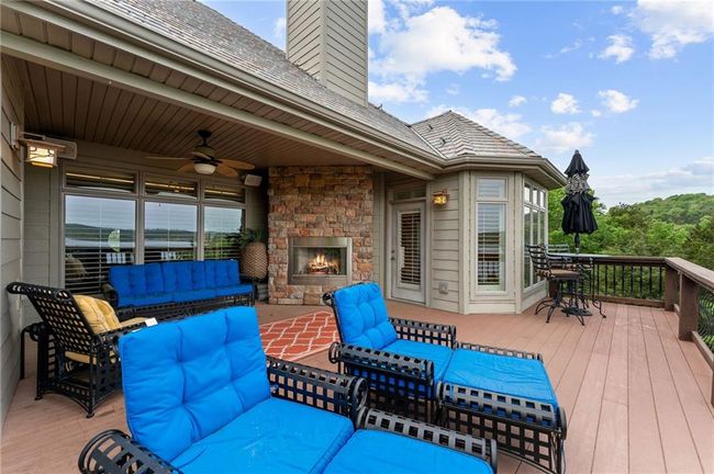 Wooden terrace featuring an outdoor living space with a fireplace and ceiling fan | Image 6