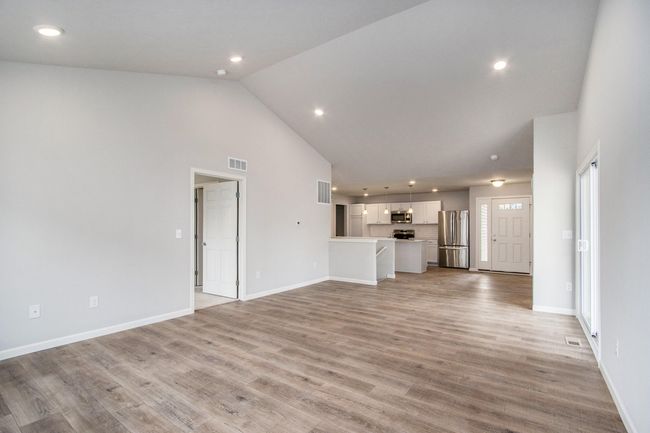 The open concept floorplan has full sight lines into the great room. There is an abundance of natural lighting from windows and is further enhanced by the vaulted ceilings and recessed lighting. | Image 10