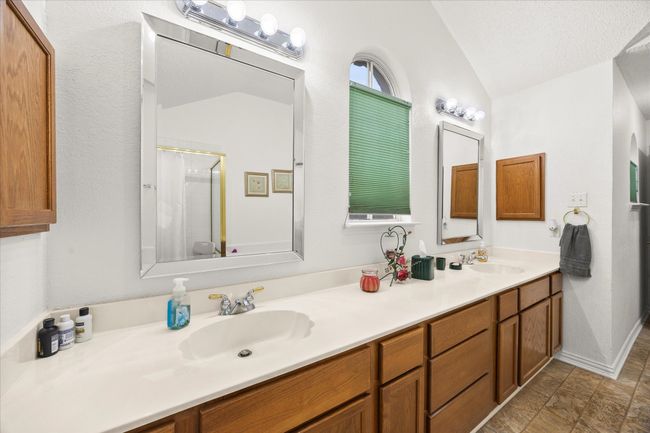 Full bathroom with vaulted ceiling, double vanity, and a shower | Image 12